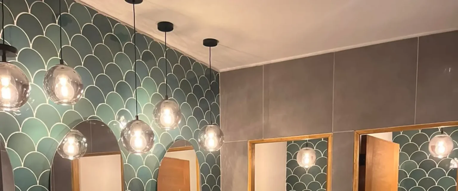 Baños de diseño con lámparas colgantes en local comercial de Providencia