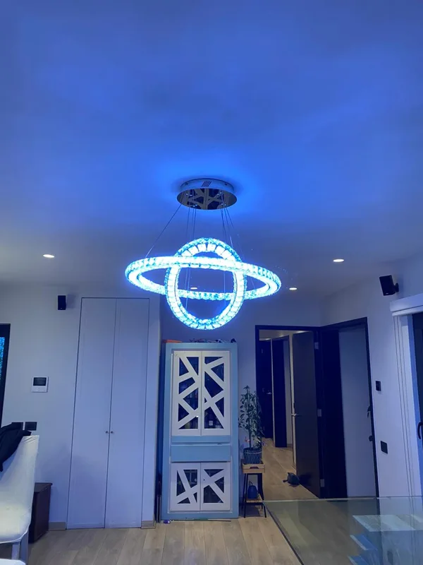 Lámpara colgante de doble aro con luz RGB instalada en un living de Las Condes