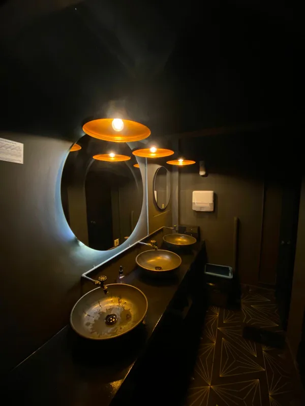 Espejo con marco iluminado y apliques de pared en un baño de Providencia